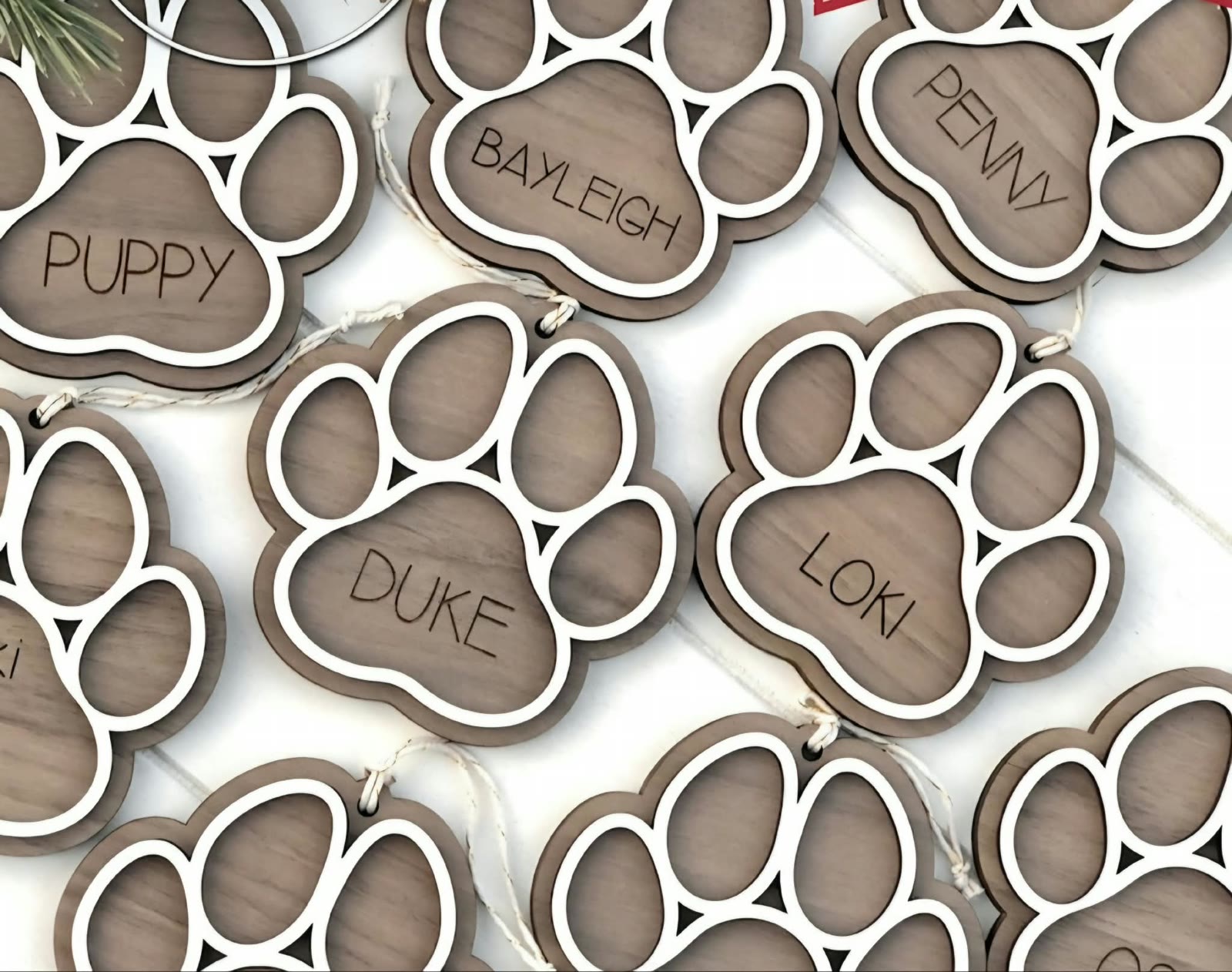 Paw print ornaments named Puppy, Bayleigh, Penny, Duke, and Loki